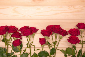 row of roses on wooden background