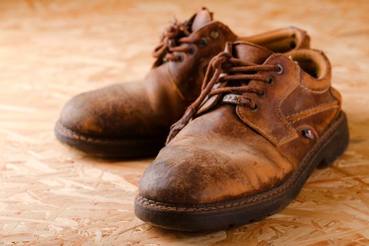 Pair of old worn shoes on wooden boad