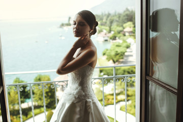 Gorgeous sexy brunette bride posing at balcony at sea resort hot