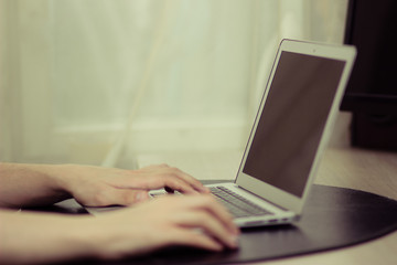 Fototapeta premium Black screen on laptop, men's hands typing, vintage colors