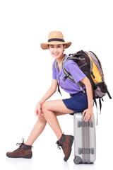 Woman traveler sitting on suitcase with backpack on white background