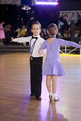 young ballroom dancers in formal costumes posing