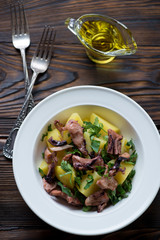 Close-up of smoked octopus and potato salad, above view