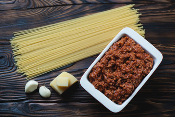 Bolognese sauce, uncooked spaghetti, parmesan and garlic