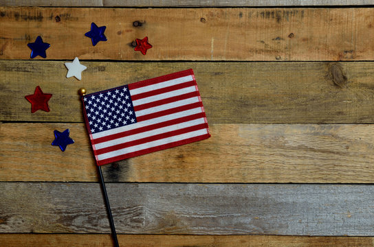 American flag with red, white and blue stars.  Set on pallet wood. 