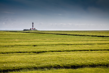 Traditional lighthouse at North Sea with blue sky and clouds