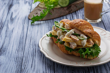 Croissant sandwich with chicken, cheese, cucumber
