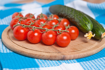 cherry tomatoes and cucumbers on the cutting board close up