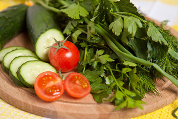 cherry tomatoes, cucumbers and parsley close-up on the board