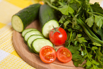 cherry tomatoes, cucumbers and parsley close-up on the board
