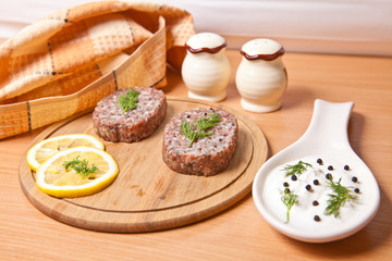 raw cutlets with lemon slices on a cutting board