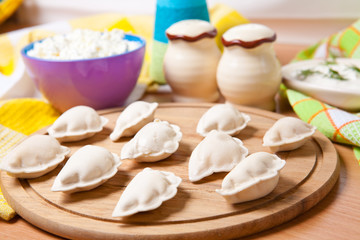 raw dumplings on a cutting board with cheese