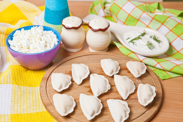 raw dumplings on a cutting board with cheese