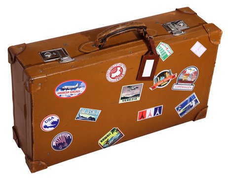 Old brown suitcase with name tag and travel sticks
