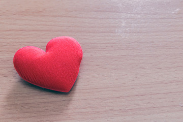 Red heart shaped on wooden background.