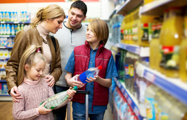 Happy family of four buying mineral water