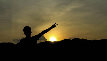 silhouette of man show arm up for achievements successful and celebrating success with sunrise