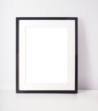 Empty picture frame on white desk