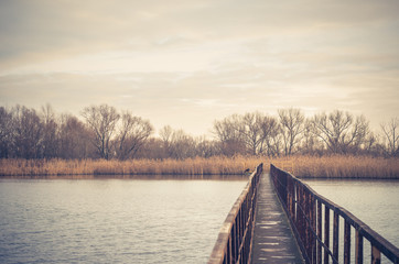 Obrazy na Plexi  Wąski stalowy most nad jesiennym jeziorem