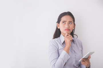 Asian Young secretary thinking while holding a mobile phone. Whi