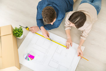 Happy couple drawing plan of their flat 