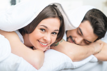 Obraz na płótnie Canvas Nice loving couple lying in bed 