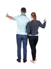 young couple pointing at wal Back view