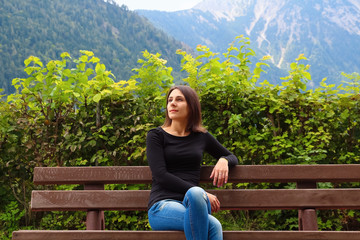 Naklejka na ściany i meble Girl on the bench on the background of Alps
