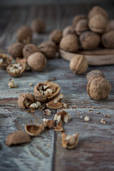 Walnut kernels and whole walnuts on rustic old wooden table
