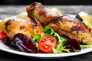 Baked chicken legs with potatoes and vegetables