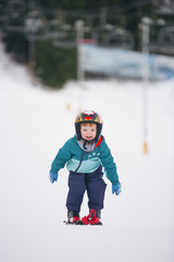 Fototapeta na wymiar toddler boy skiing in the mountains