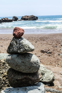 Steinturm am Strand mit rotem Stein obenauf