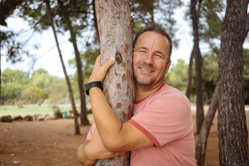 Adult man hugging the tree