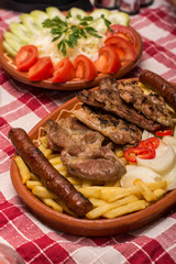 Mixed grilled meat with tomato salad