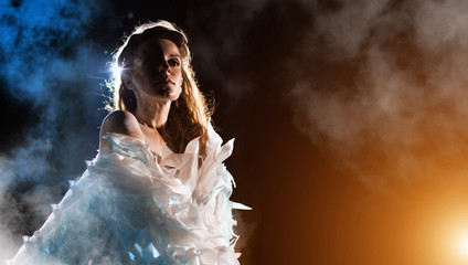 Portrait of a white angel on the color fog background