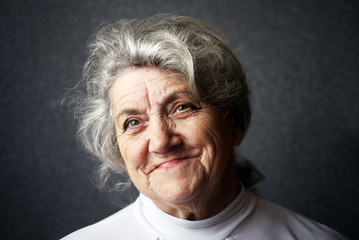 Happy old granny portrait on a dark background - obrazy, fototapety, plakaty