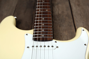 Electric guitar on wooden background, close up