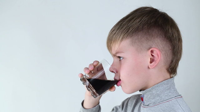 Boy drinking fizzy drink on a white background