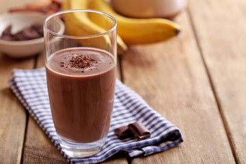 Glass of chocolate milk on table close-up