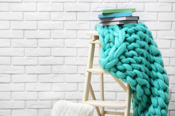 Knitted woolen blanket on stairs, on home interior background