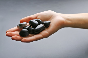 Woman holding semiprecious stones in her hand on dark grey background