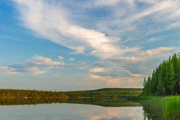 Summer evening landscape with lake and clouds on the blue sky 