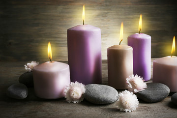 Obraz na płótnie Canvas Spa set with candles, pebbles and flowers on wooden background, close up