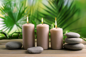 Obraz na płótnie Canvas Spa composition of candles, stones and bamboo on blurred background