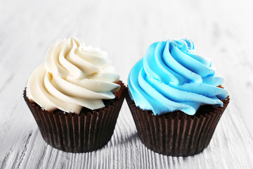 Fresh delicious cupcakes in a row on white wooden  background