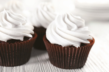 White cupcakes on wooden table