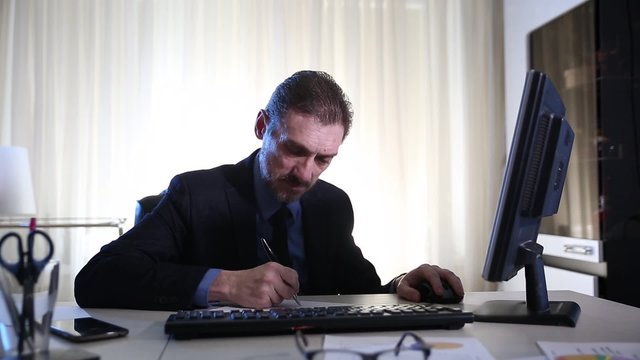cheerful businessman working with business papers and computer
