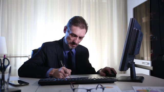 cheerful businessman working with business papers and computer