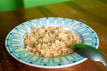 soup / A plate with hot soup with noodles standing on a wooden table
