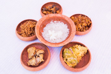 rice in ice water with side dishes such deep fried pork, onion,